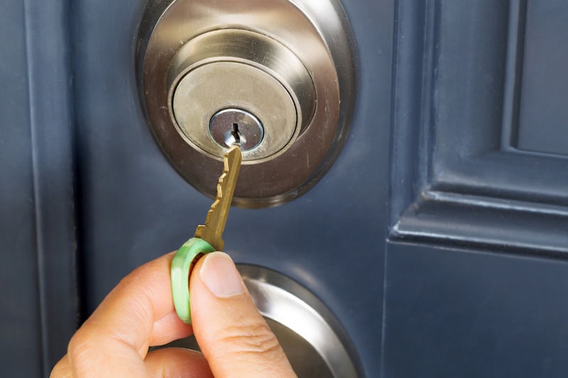 Commercial Lock Maintenance for Business Security. A key going inside a door lock.
